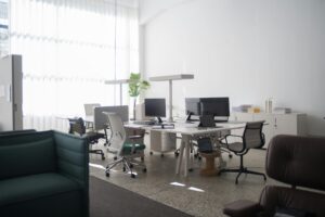 A spacious office interior in Portugal with desks, chairs, and computers under natural light.