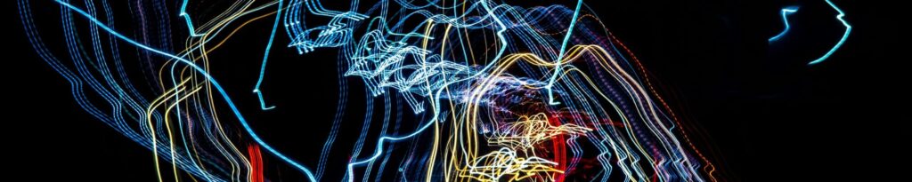 Abstract backdrop of glowing vivid freezelights making shimmering colorful lines in dark night